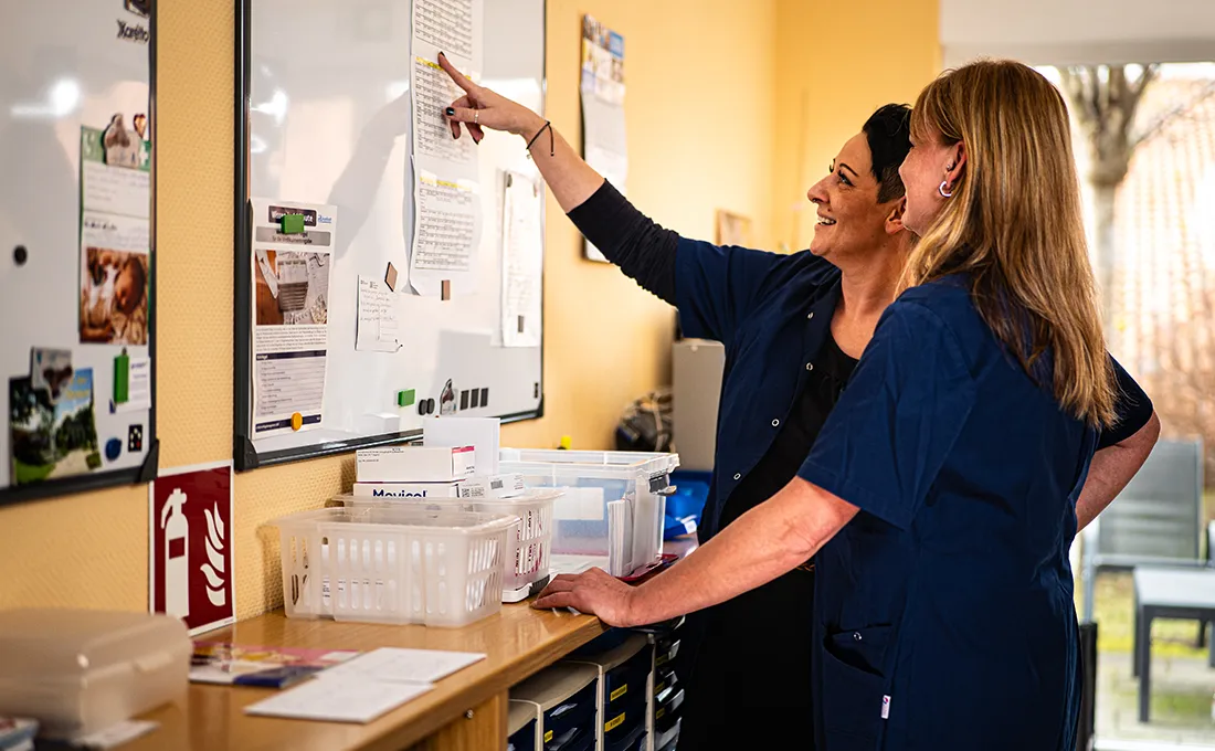 Pflegekräfte besprechen Einsatzplanung vor einem Whiteboard