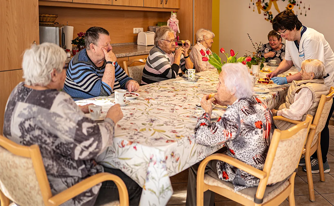 Senioren sitzen gemeinsam am Tisch in einer Wohngemeinschaft
